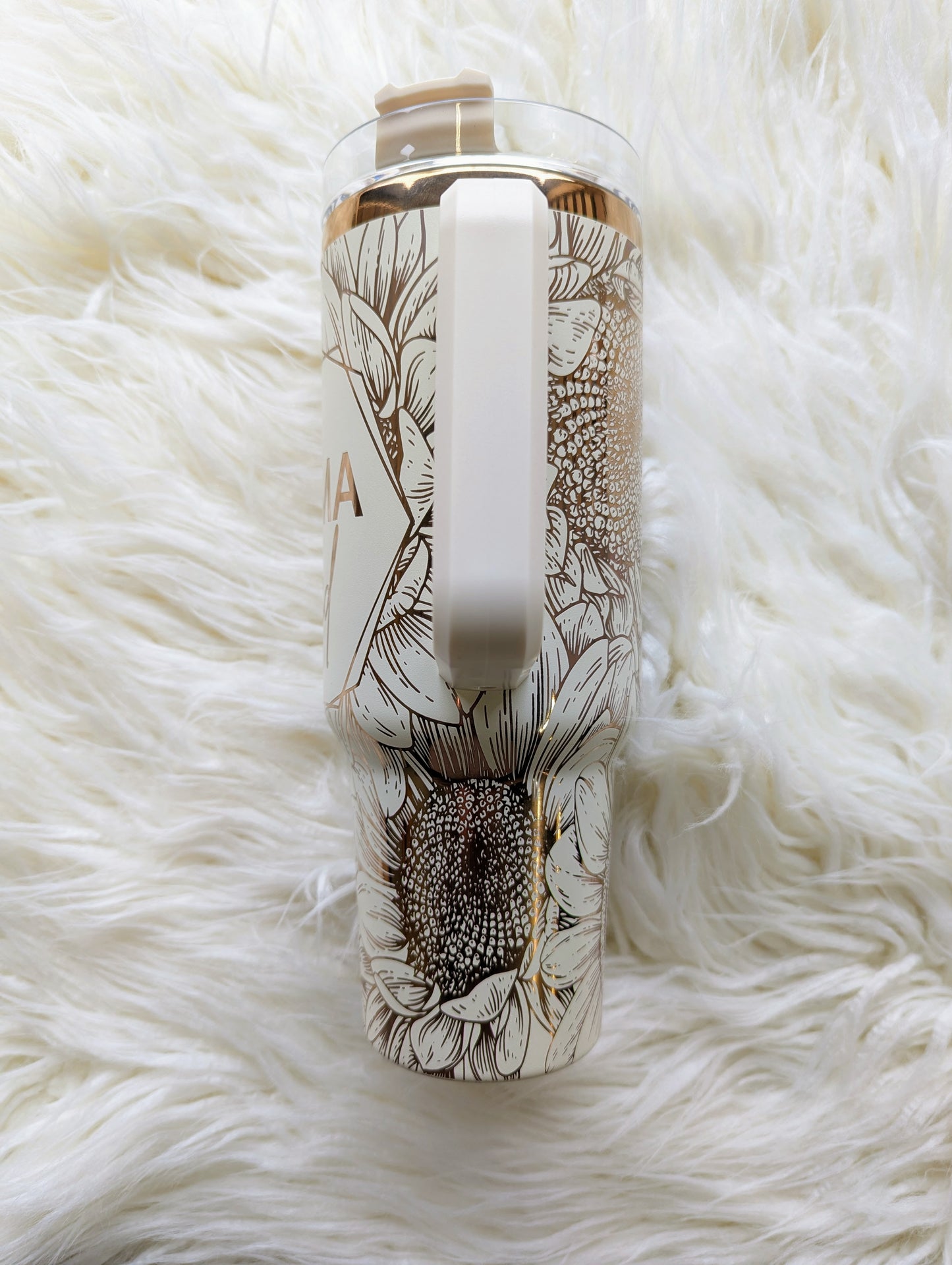 Photo of a 40 oz insulated tumbler with handle permanently engraved with a sunflower pattern and the text Mama Tried