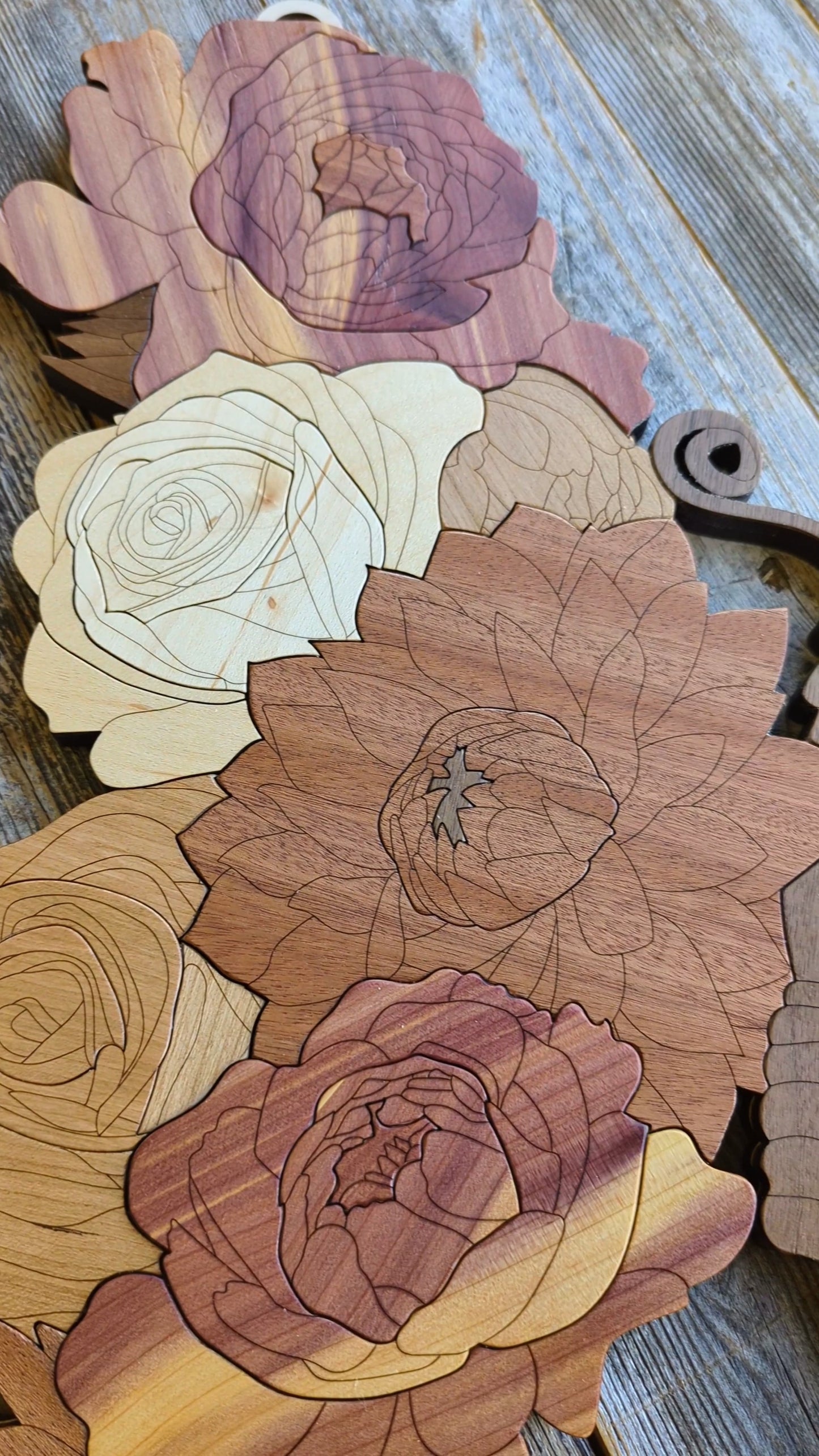 Close-up of one wing of the wooden butterfly, showing detailed floral layering and smooth, shaped edges.