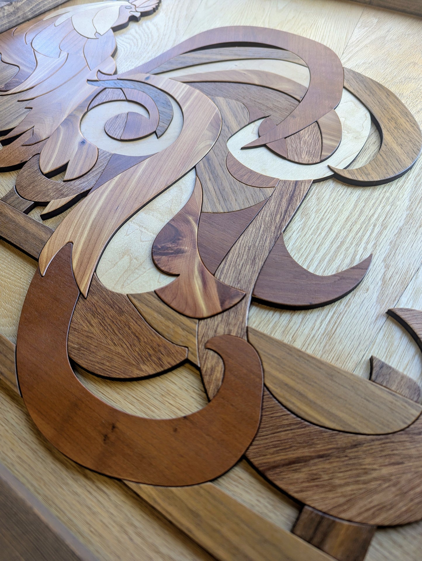 Close-up of rooster’s tail showcasing the swirling wood grain and variety of veneer species.