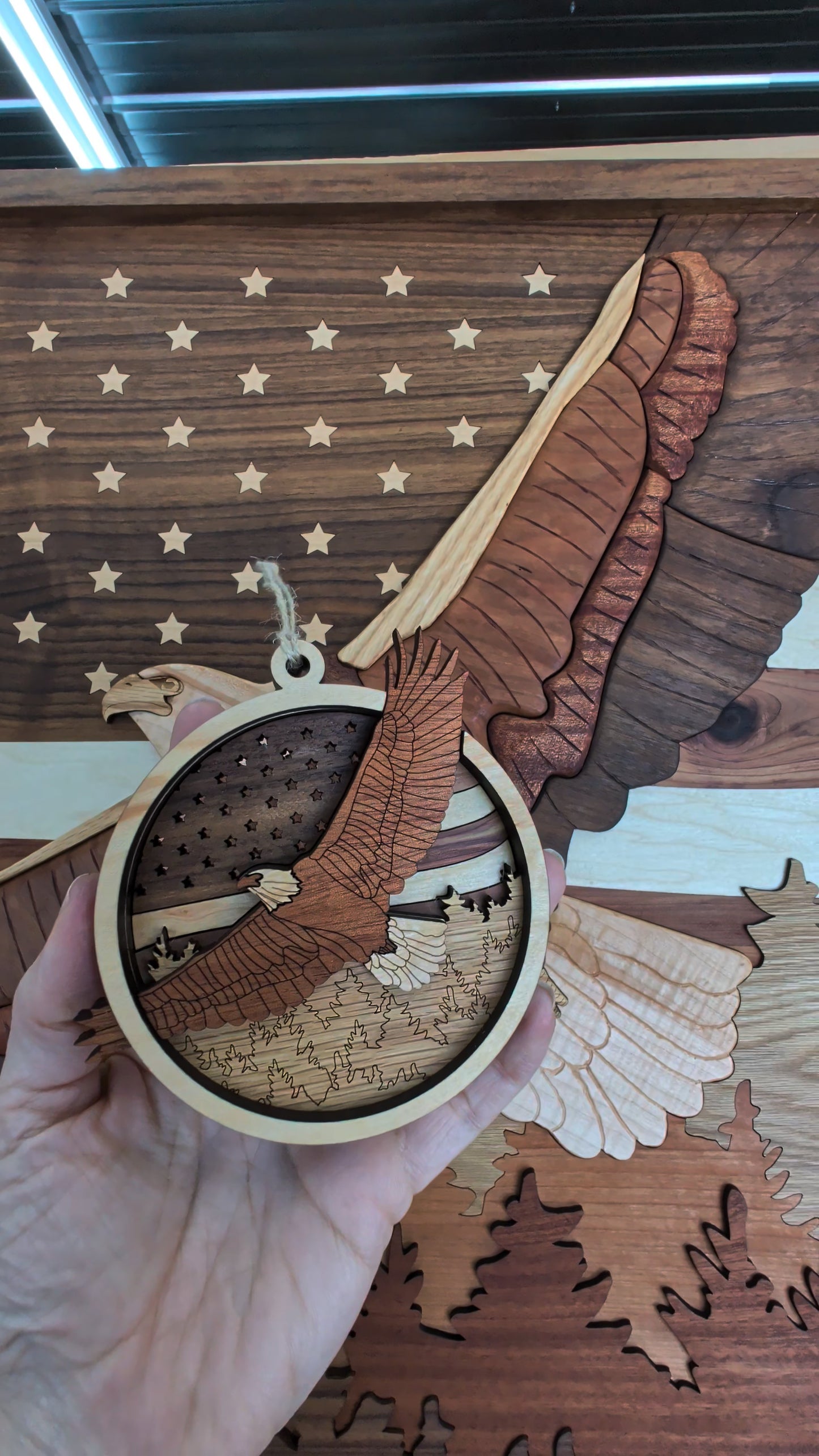 Wooden ornament with an eagle design held against a wooden American flag background