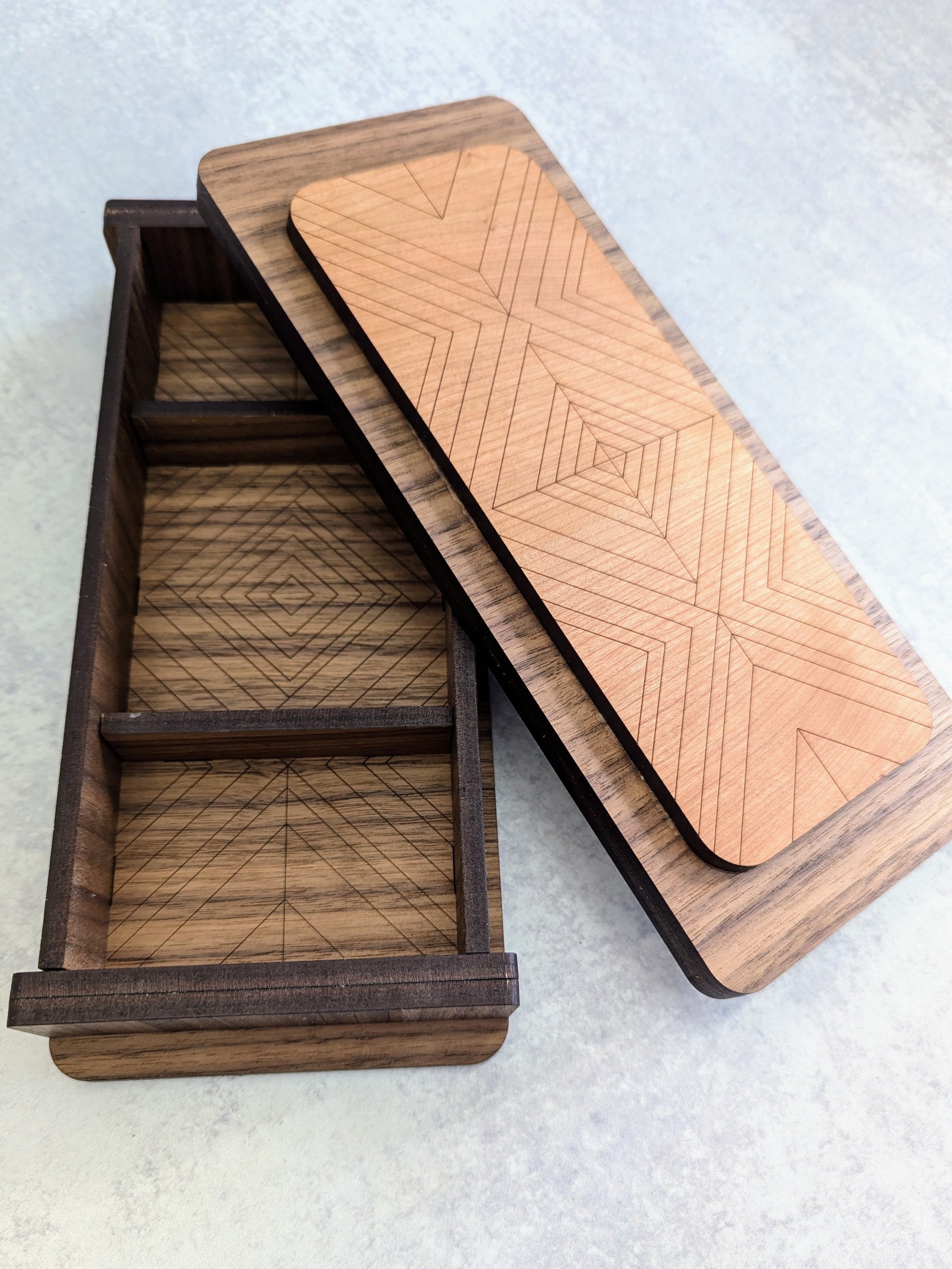 Top view of beautiful handcrafted cribbage board and storage box with lid removed to show intricate details inside and on the bottom of the lid.
