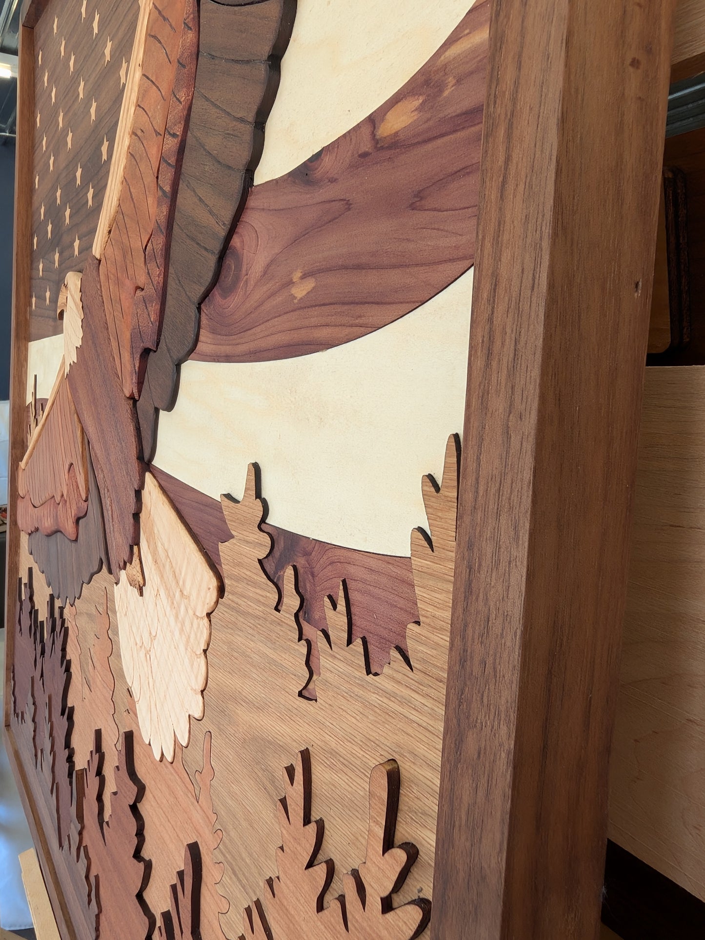 Wooden wall art with cut-out shapes of eagle, trees, and mountains