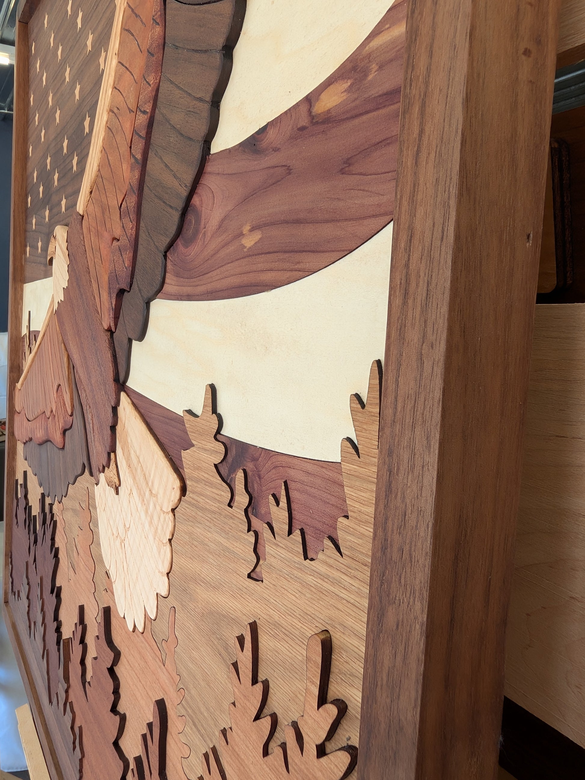 Wooden wall art with cut-out shapes of eagle, trees, and mountains