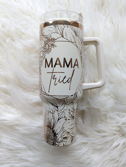 Photo of a 40 oz insulated tumbler with handle permanently engraved with a sunflower pattern and the text Mama Tried