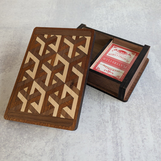 Handcrafted wooden playing card box made with layered cherry, walnut, maple, and mahogany veneer. Intricate geometric design on the lid with rich natural tones. Designed to hold two standard decks of cards.