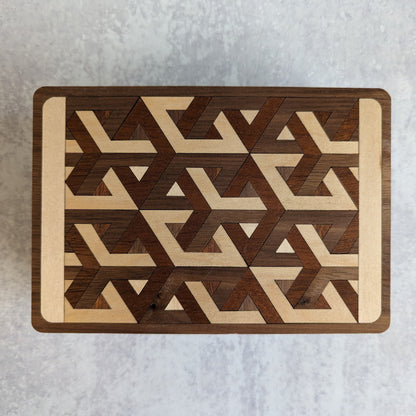 Handcrafted wooden playing card box made with layered cherry, walnut, maple, and mahogany veneer. Intricate geometric design on the lid with rich natural tones. Designed to hold two standard decks of cards.