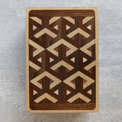 Handcrafted wooden playing card box made with layered cherry, walnut, maple, and mahogany veneer. Intricate geometric design on the lid with rich natural tones. Designed to hold two standard decks of cards.