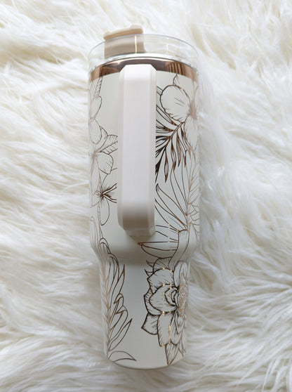 Photo is a 40 oz insulated tumbler in cream/copper engraved with a tropical flower pattern