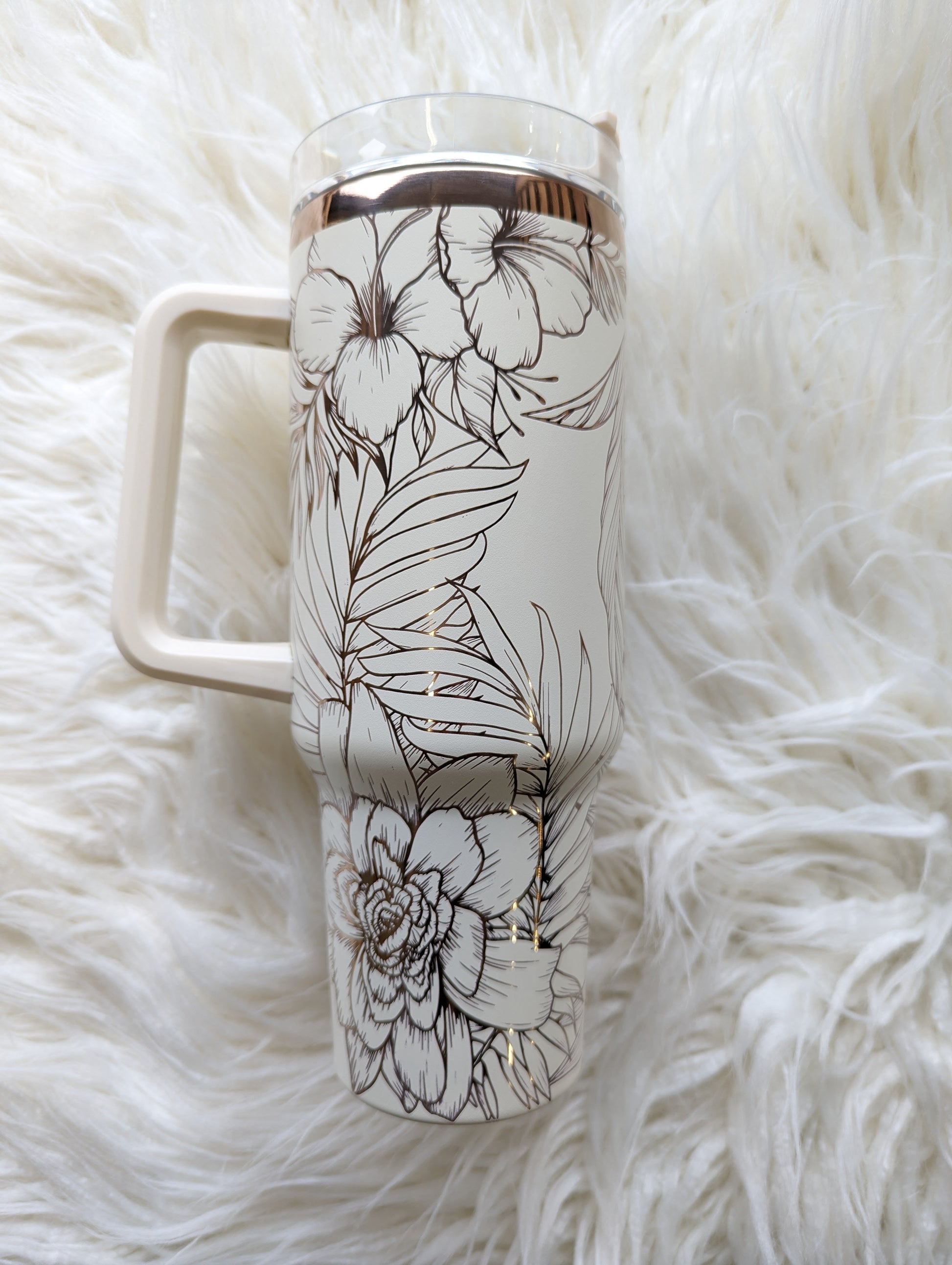 Photo is a 40 oz insulated tumbler in cream/copper engraved with a tropical flower pattern