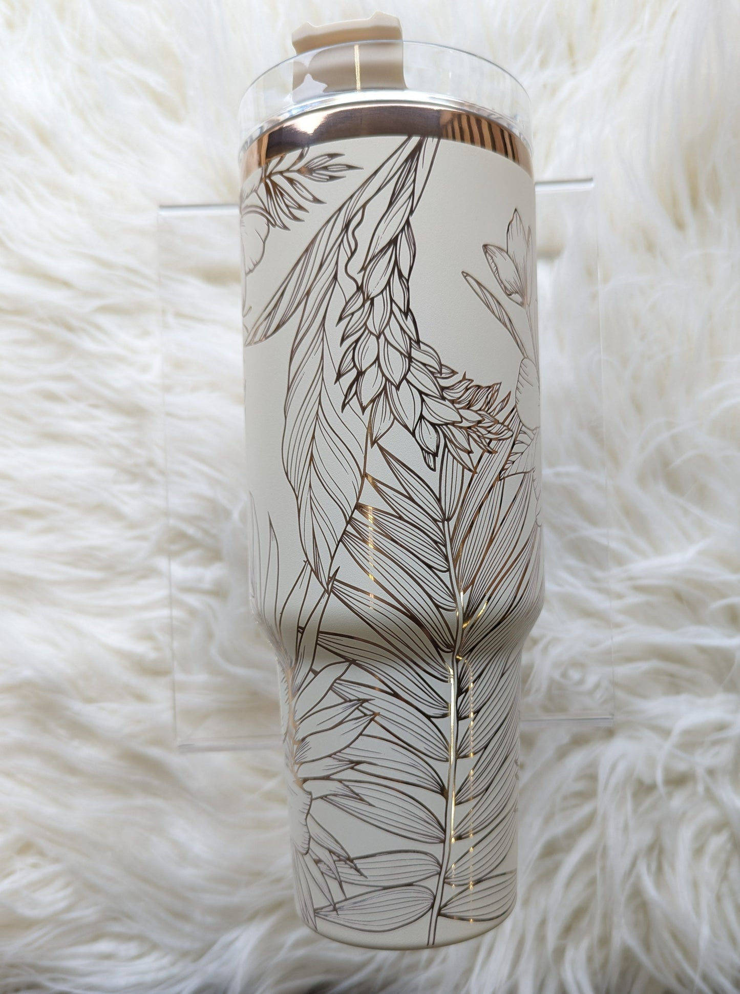 Photo is a 40 oz insulated tumbler in cream/copper engraved with a tropical flower pattern