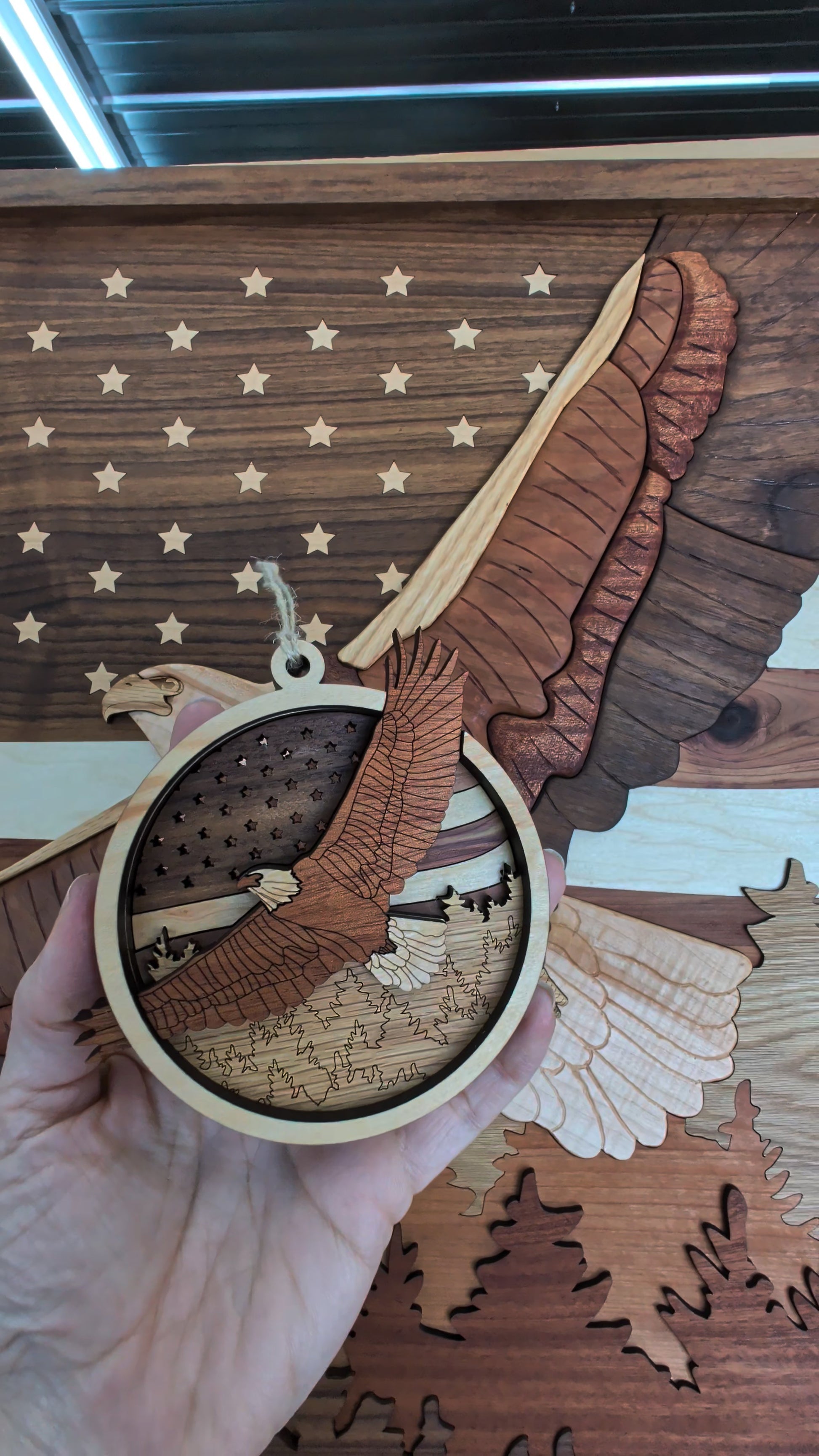 Wooden ornament with an eagle design held against a wooden American flag background