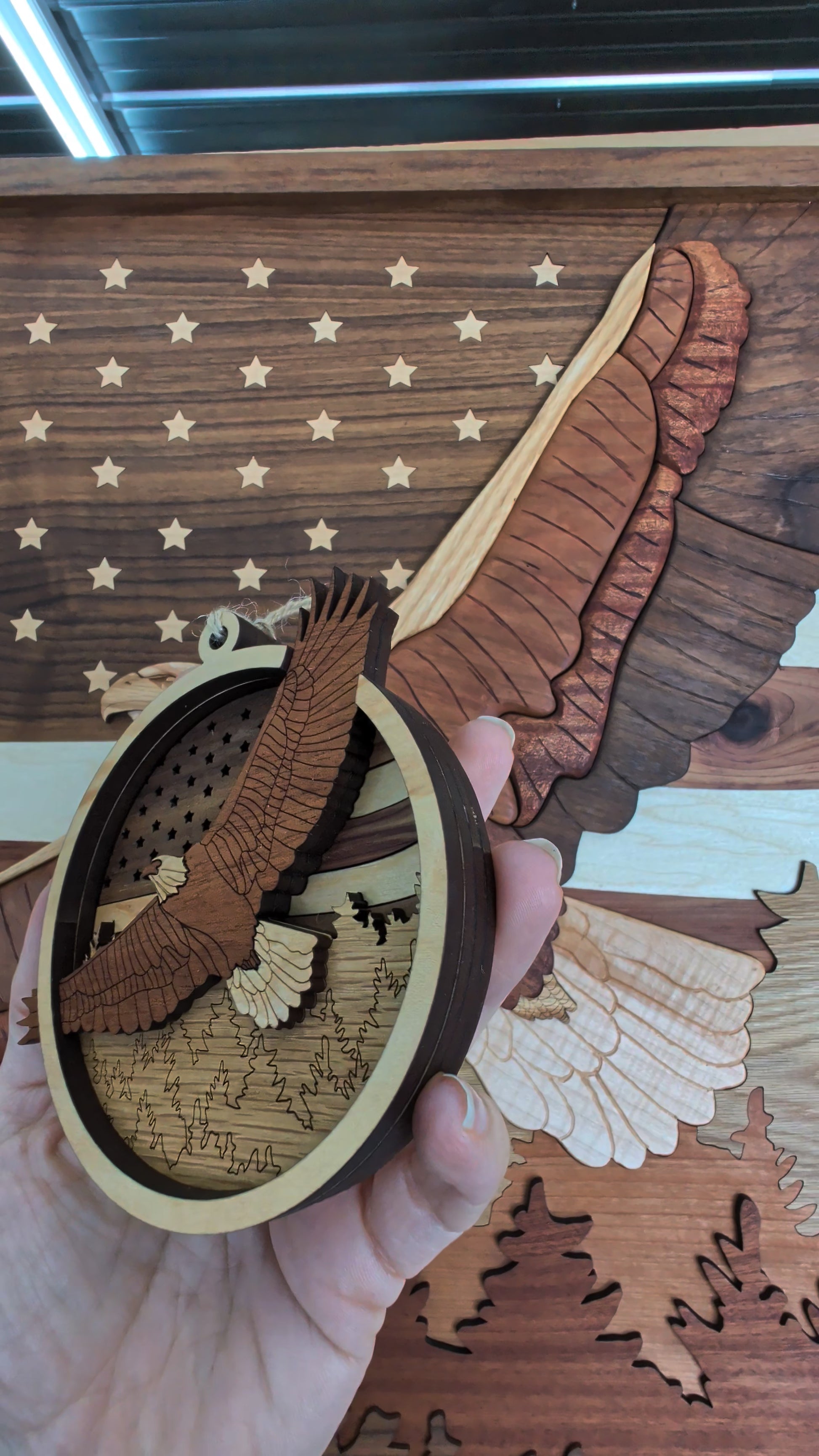 Wooden eagle ornament held in front of a wooden American flag background