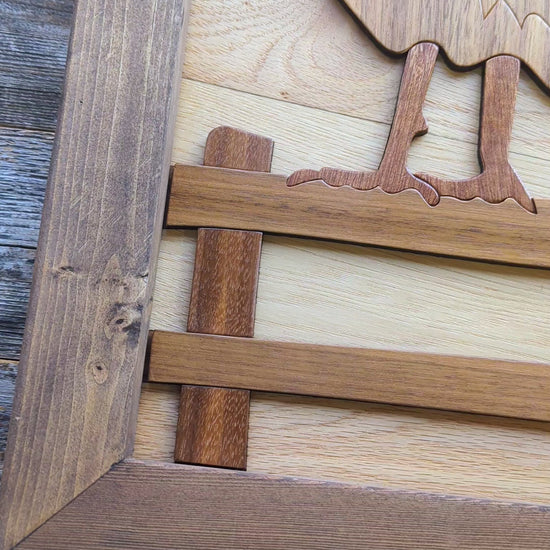 Video zooming in on the rooster’s foot on the wooden fence, highlighting detail and craftsmanship in the lower section.