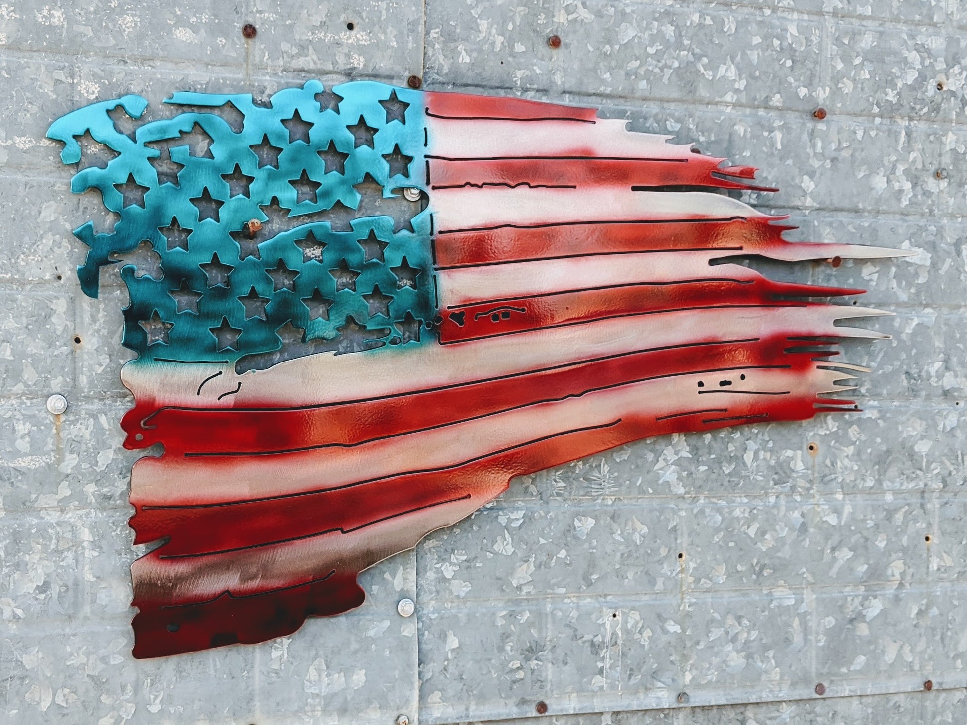 American flag cut from steel and airbrushed with red and blue paint for the red stripes and blue background.